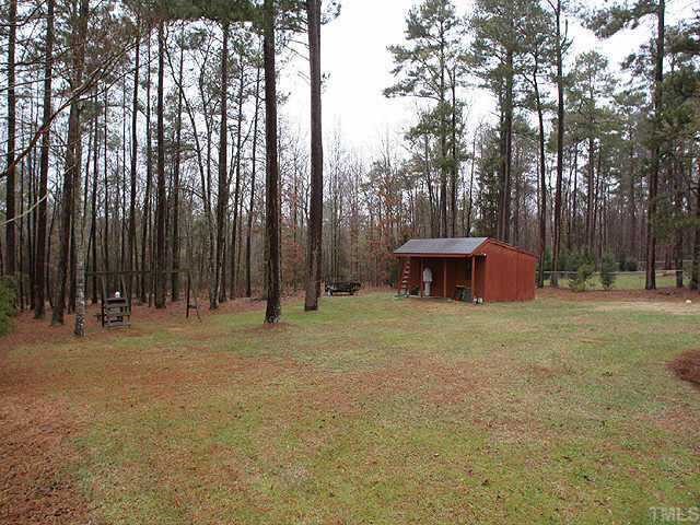 5015 Raintree Road Durham, NC 27712 - Photo 9 of 10 a backyard of a house with trees and plants