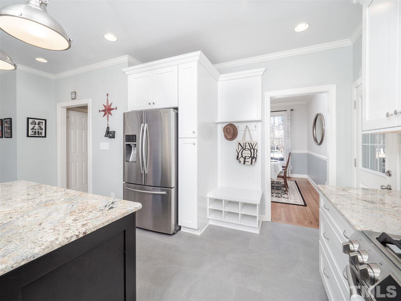 1003 Beringer Place Apex, NC 27502 - Photo 11 of 30 a kitchen with granite countertop a refrigerator and a sink