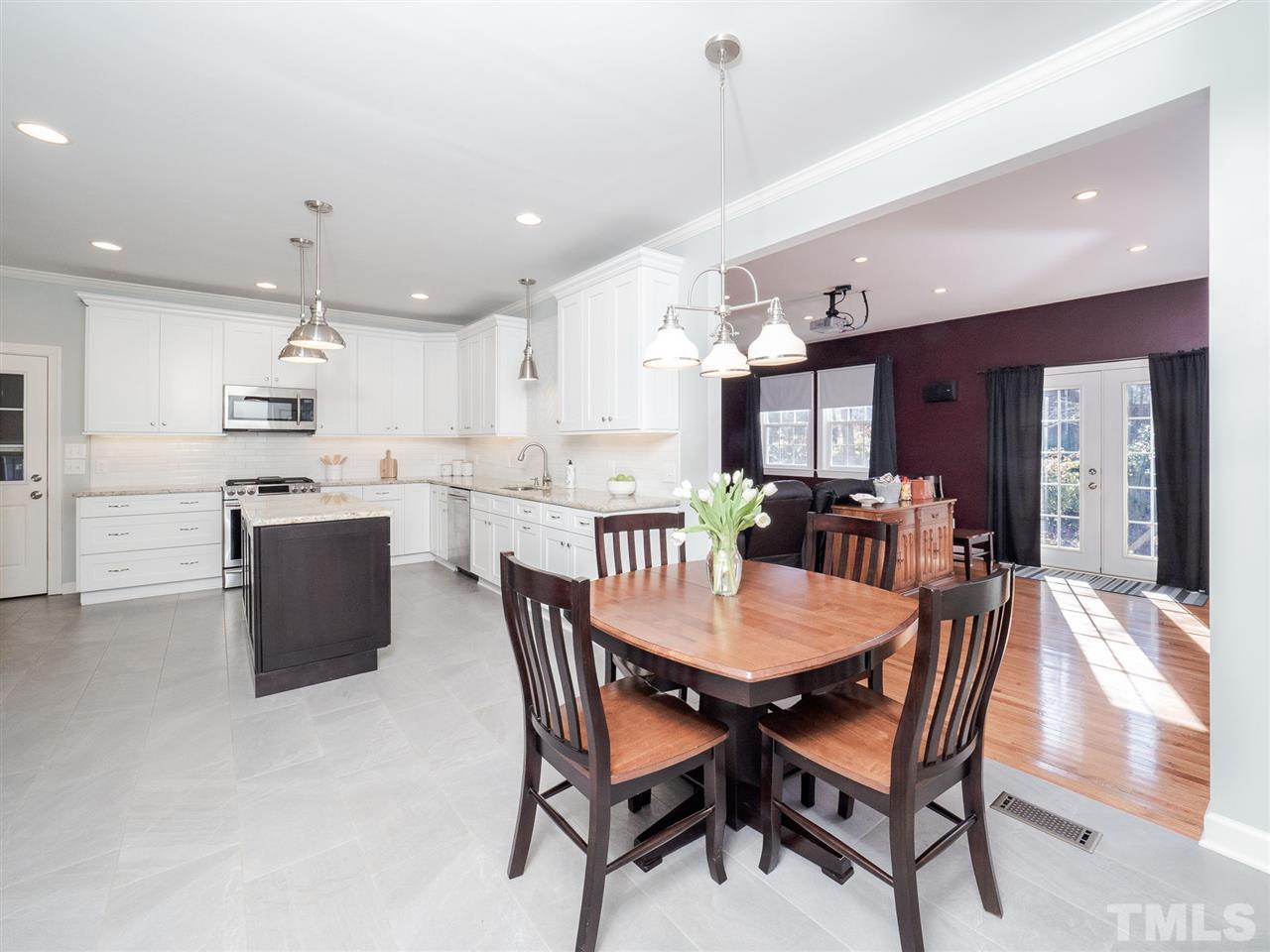 1003 Beringer Place Apex, NC 27502 - Photo 12 of 30 a dining room with kitchen island a table and chairs
