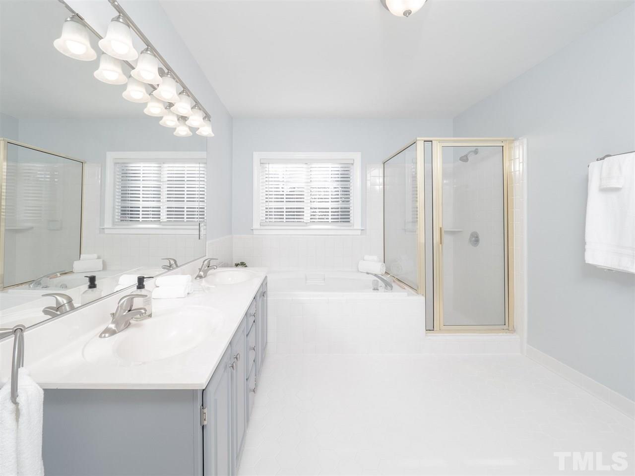 1003 Beringer Place Apex, NC 27502 - Photo 21 of 30 a large bathroom with a tub sink and mirror