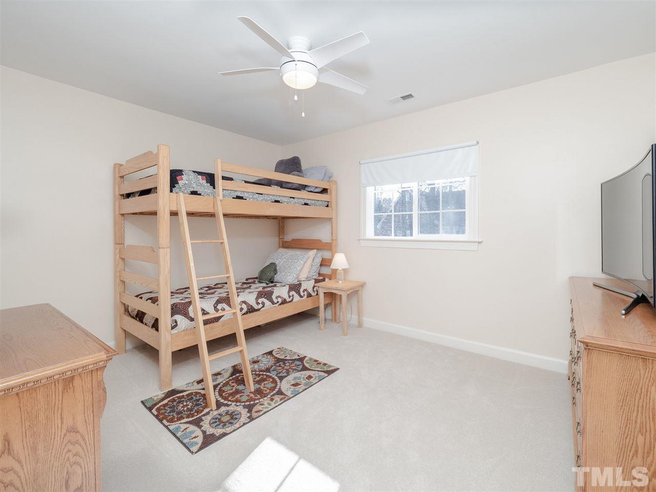 1003 Beringer Place Apex, NC 27502 - Photo 23 of 30 a living room with furniture a flat screen tv and a window