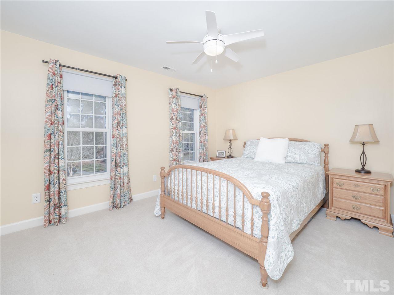 1003 Beringer Place Apex, NC 27502 - Photo 24 of 30 a spacious bedroom with a bed and a cabinets