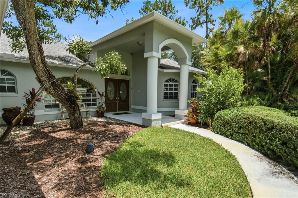 2053 17th Street Southwest Naples, FL 34117 - Photo 5 of 47 a front view of a house with garden