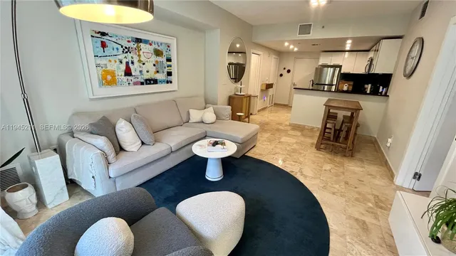 a living room with furniture a fireplace and a kitchen view