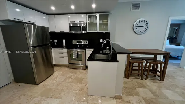 a kitchen with stainless steel appliances granite countertop a refrigerator a stove a sink and a refrigerator