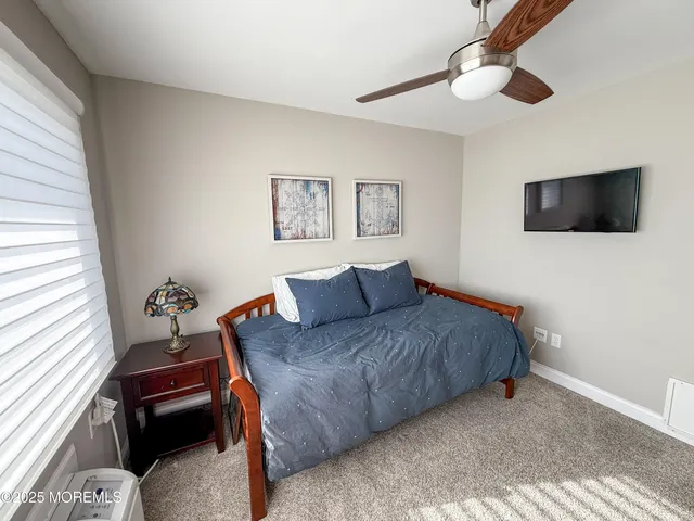 a living room with a bed furniture and a flat screen tv