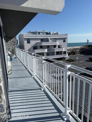 a view of a balcony with a car parked on the road