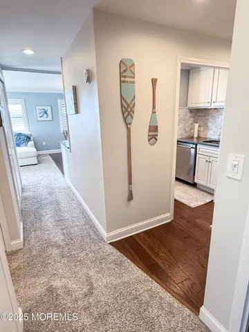 a view of a kitchen with fridge and wooden floor