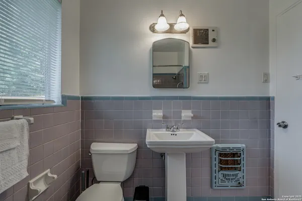 a bathroom with a toilet a sink and mirror