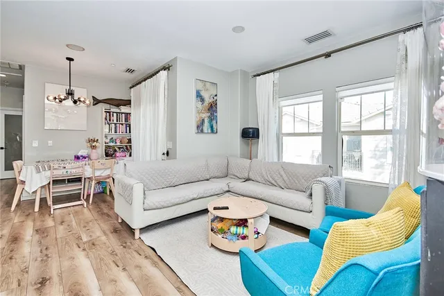 a living room with furniture wooden floor and a chandelier
