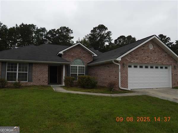 a front view of a house with a garden and yard