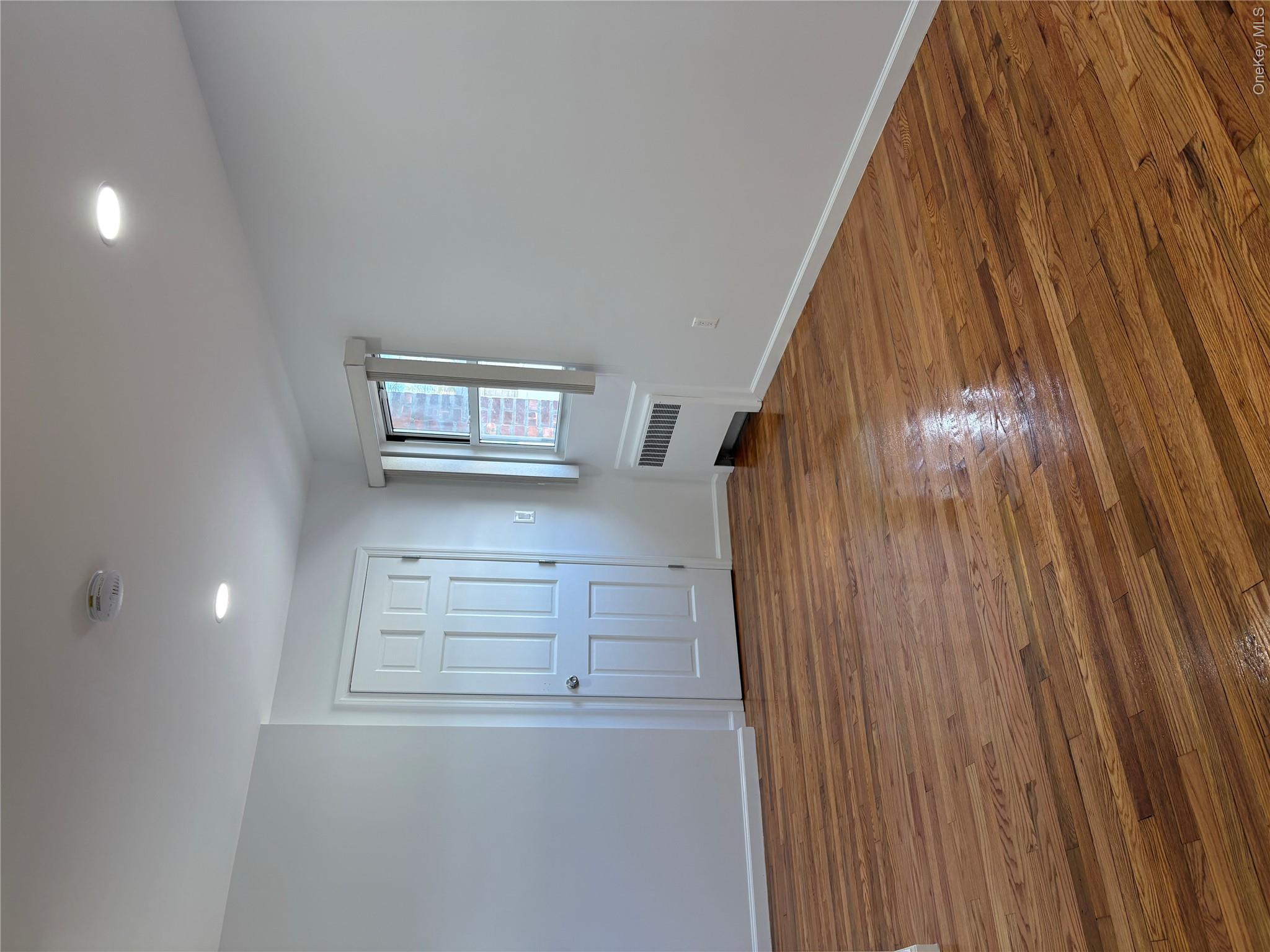 2262 Leighton Road Elmont, NY 11003 - Photo 4 of 12 a view of empty room with wooden floor and fan