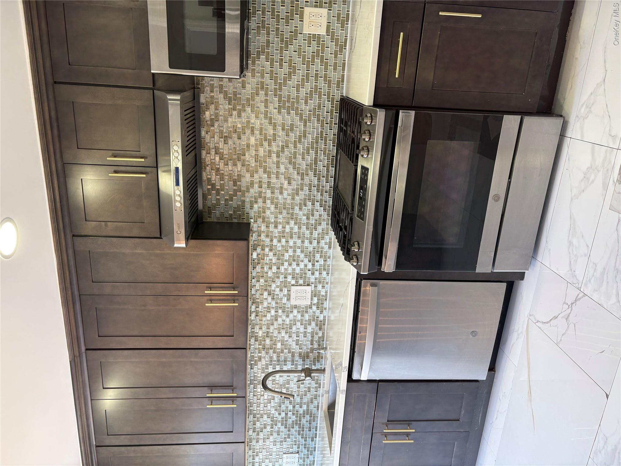 2262 Leighton Road Elmont, NY 11003 - Photo 9 of 12 a kitchen with stainless steel appliances granite countertop a stove microwave and sink