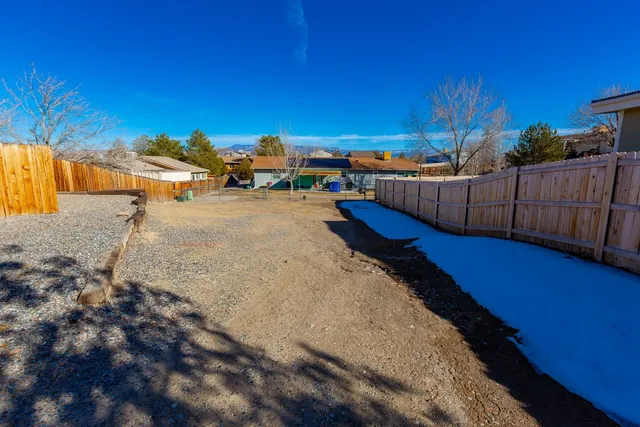 a view of a backyard with wooden fence