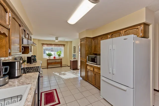 a kitchen with stainless steel appliances granite countertop a refrigerator and a stove top oven