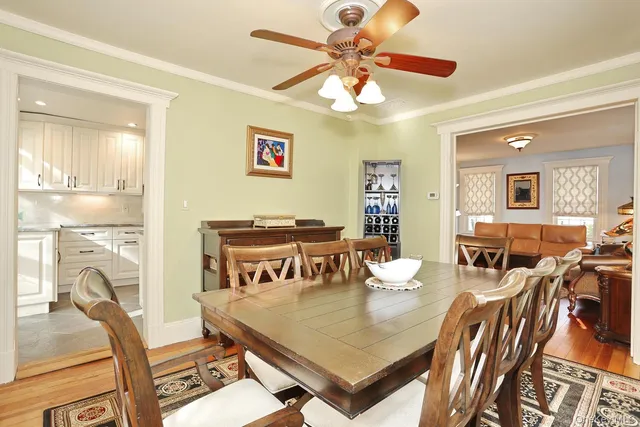 a view of a dining room with furniture a chandelier and wooden floor