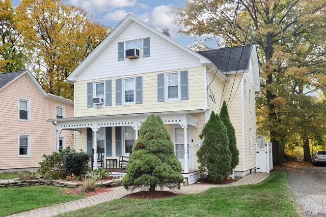 front view of a house with a yard and an trees