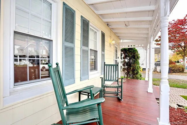 a porch with chairs and wooden floor