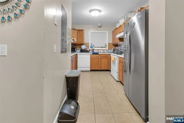 a kitchen with a refrigerator and white cabinets