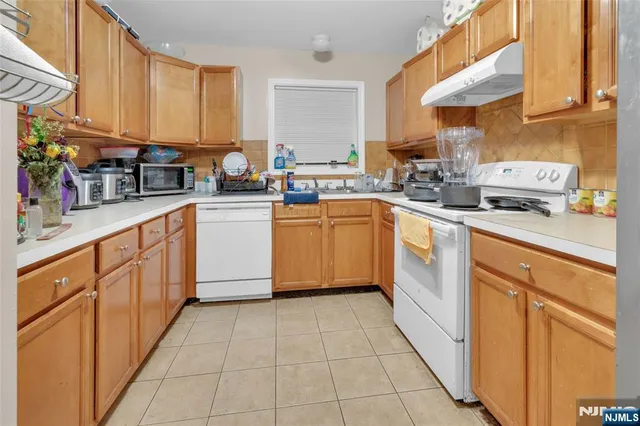 a kitchen with stainless steel appliances granite countertop a sink counter space cabinets and a large window