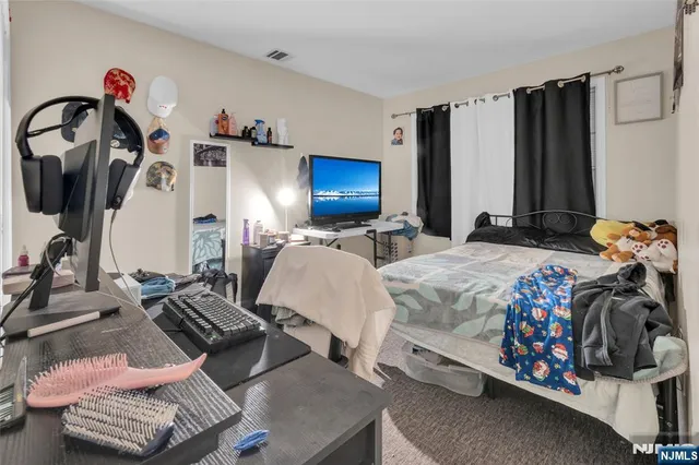 a bedroom with furniture and a flat screen tv