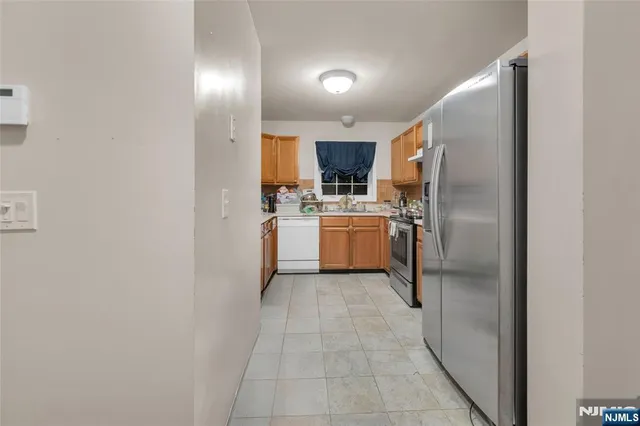 a kitchen with stainless steel appliances granite countertop a refrigerator and a stove