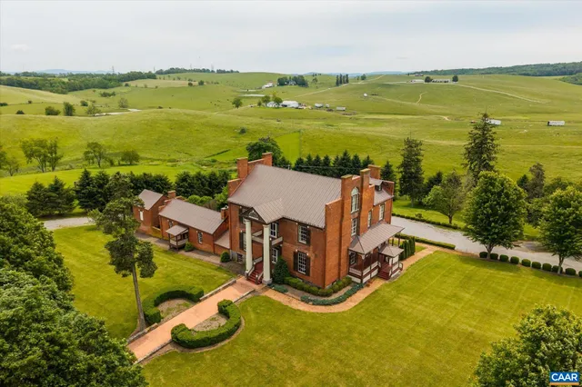 an aerial view of a house with pool garden and outdoor seating