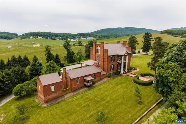 an aerial view of a house with a garden and lake view
