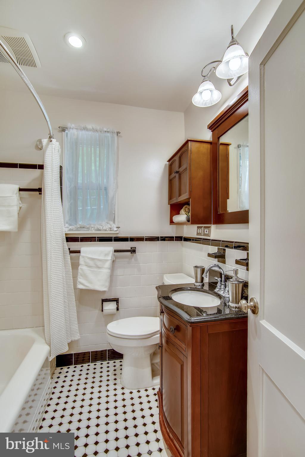 9051 Manchester Road Silver Spring, MD 20901 - Photo 18 of 37 a kitchen with a sink toilet a mirror and cabinets