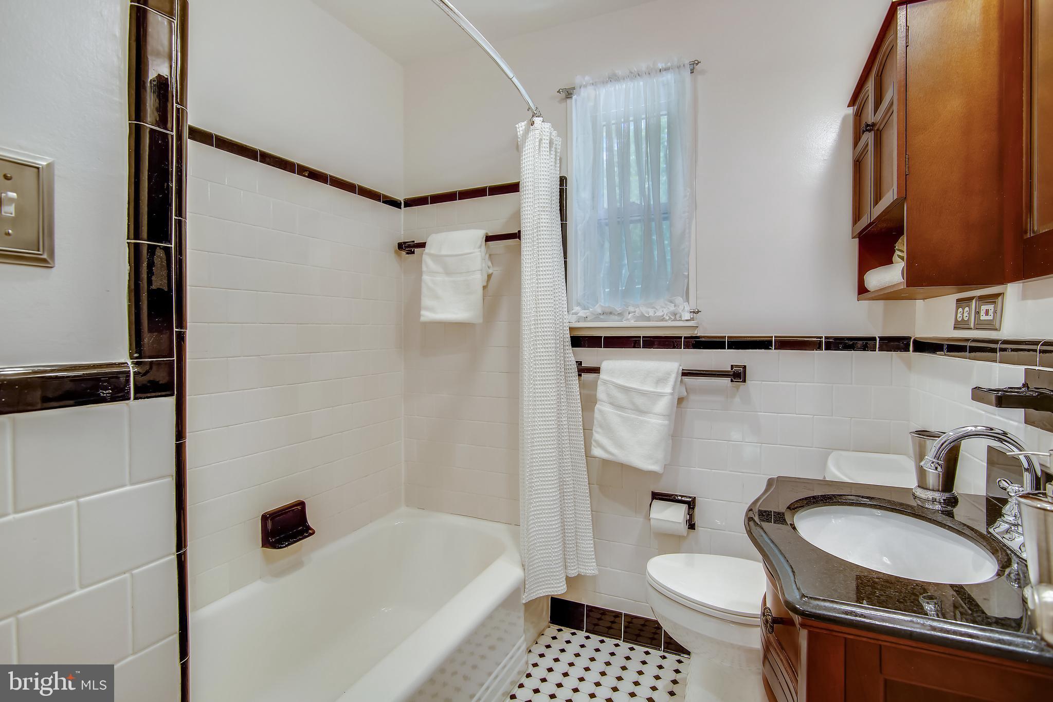 9051 Manchester Road Silver Spring, MD 20901 - Photo 19 of 37 a bathroom with a sink a toilet and a mirror