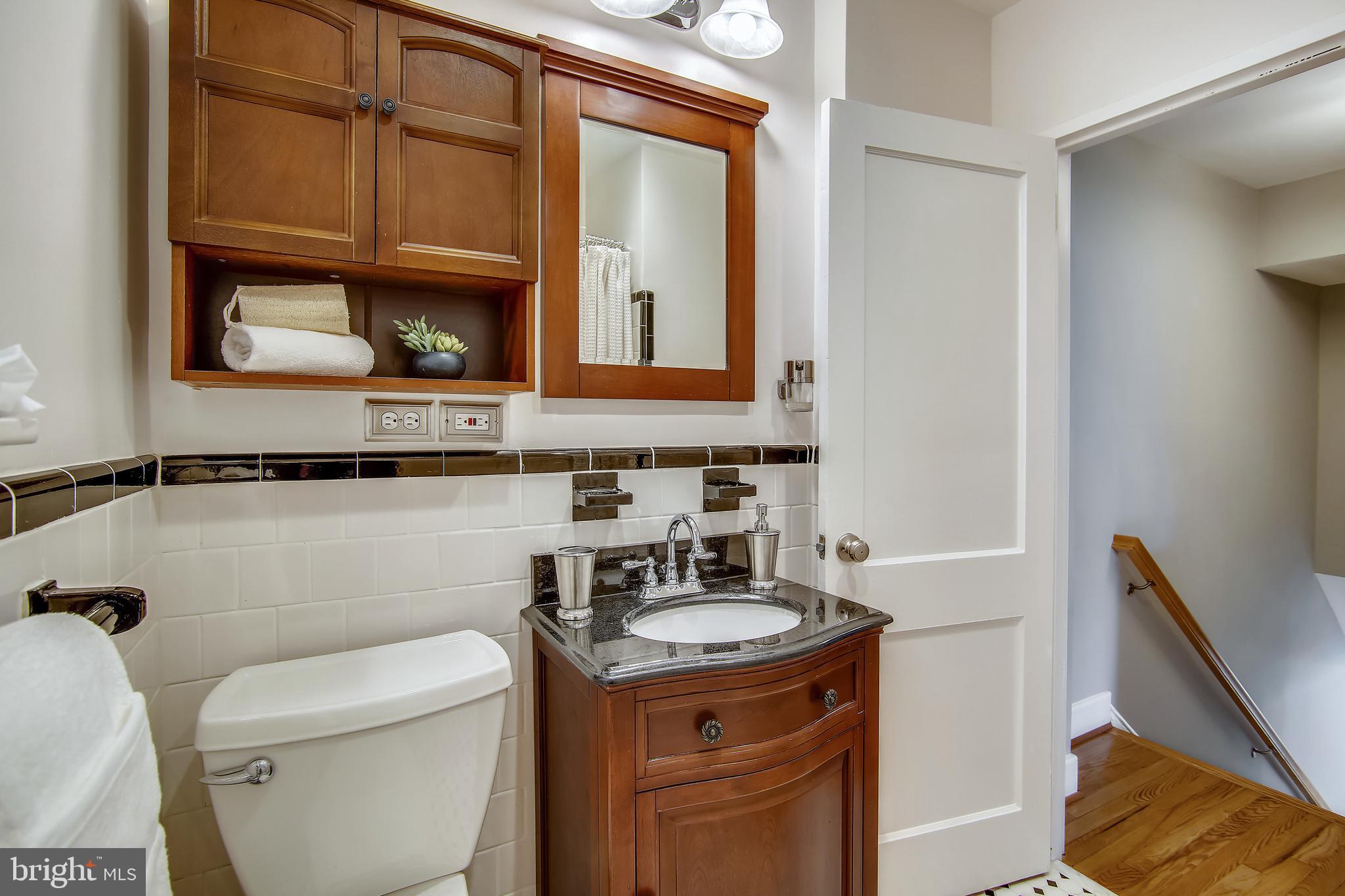 9051 Manchester Road Silver Spring, MD 20901 - Photo 20 of 37 a bathroom with a toilet a sink and a mirror