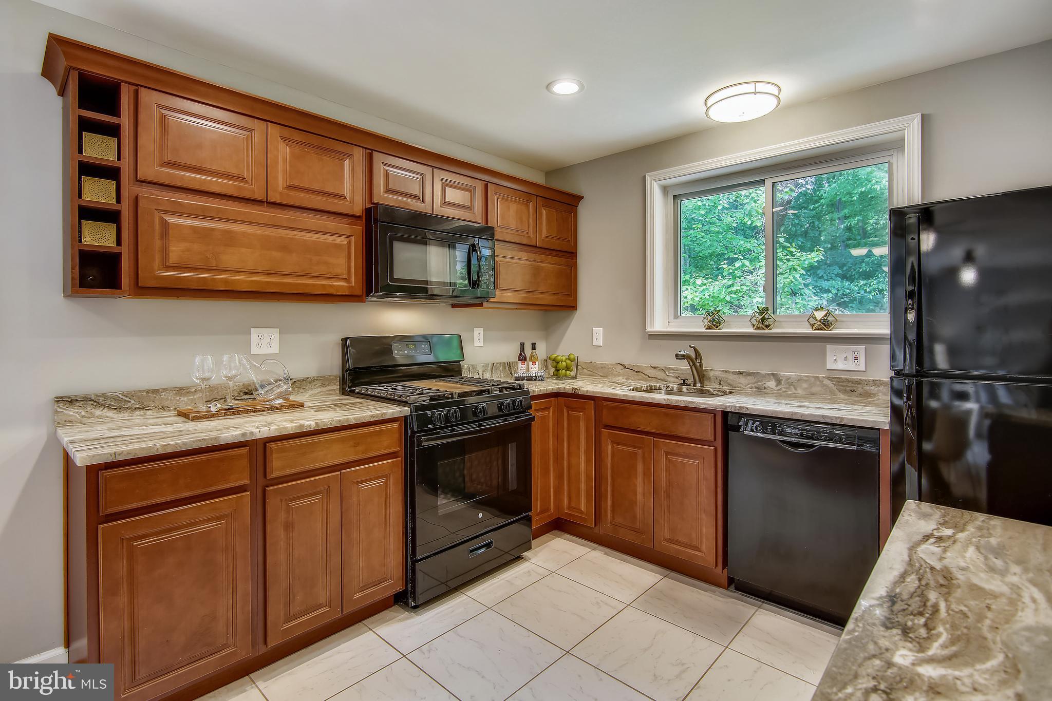 9051 Manchester Road Silver Spring, MD 20901 - Photo 10 of 37 a kitchen with stainless steel appliances granite countertop a stove sink and cabinets