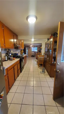 a kitchen with stainless steel appliances a stove a sink cabinets and living room view