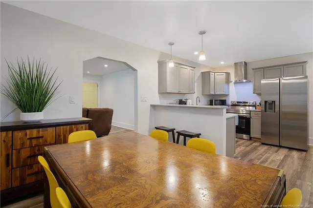 a kitchen with a table chairs refrigerator and microwave