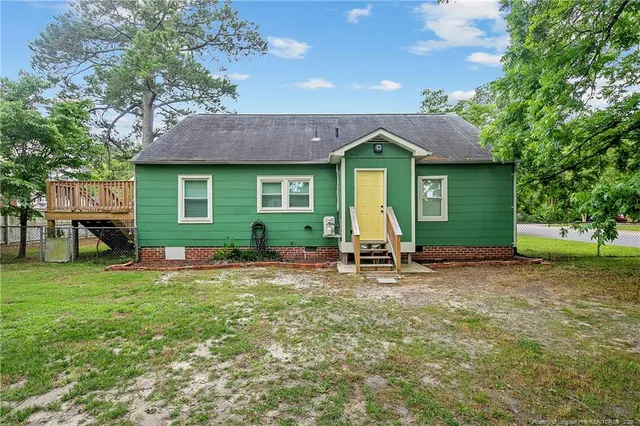 a front view of a house with a garden and chairs