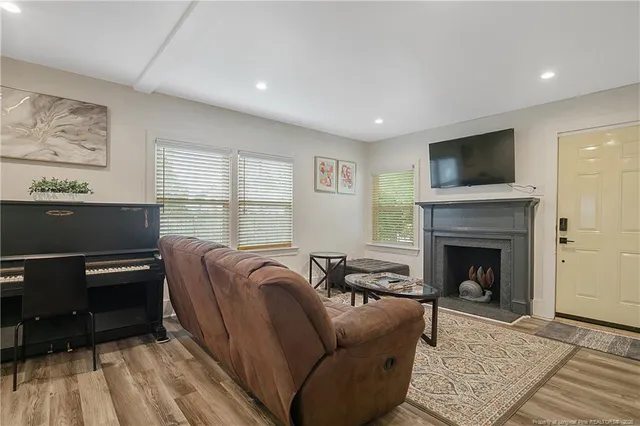 a living room with furniture a flat screen tv and a fireplace