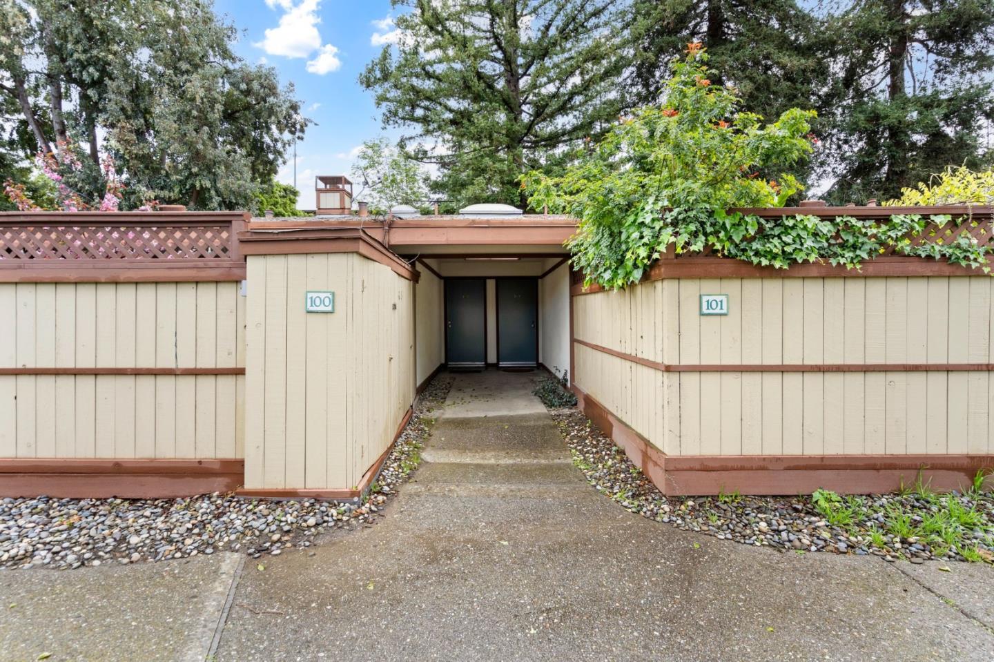 500 West Middlefield Road, Unit 101 Mountain View, CA 94043 - Photo 2 of 37 a view of a backyard with a large tree and wooden fence