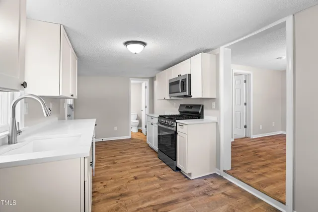 a kitchen with a sink cabinets stainless steel appliances and a window