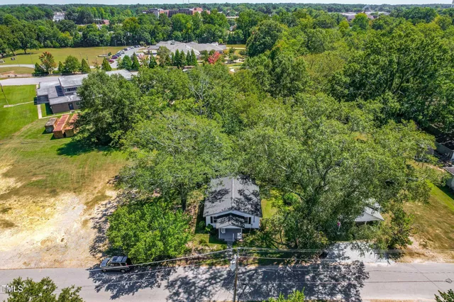 an aerial view of a house with a yard and lake view