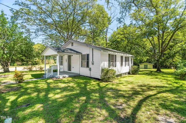 a view of a house with a yard and sitting area