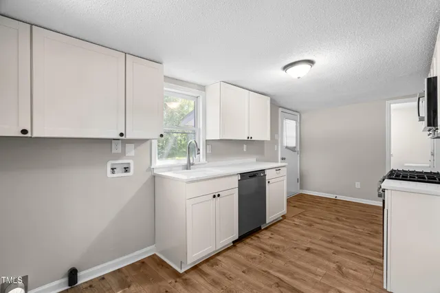 a kitchen with a sink cabinets stainless steel appliances and a window