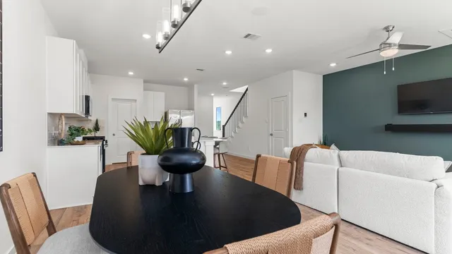 a living room with furniture a flat screen tv and kitchen view