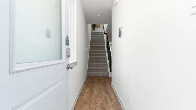a view of a hallway with wooden floor and entryway