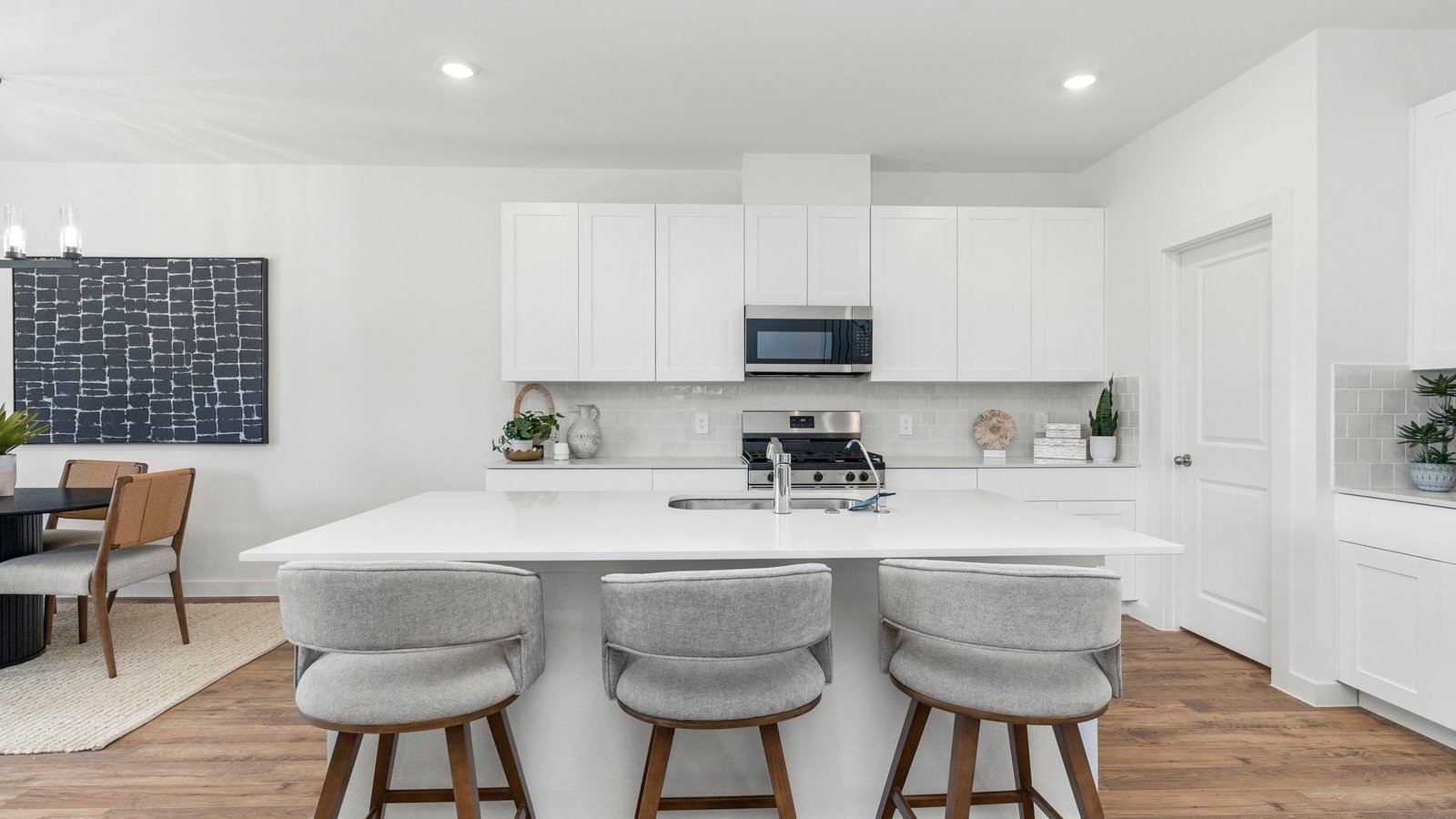 3531 Blue Mockingbird Street Katy, TX 77494 - Photo 6 of 41 a kitchen with stainless steel appliances a sink a stove a table and chairs