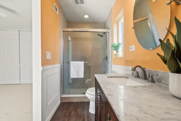 a bathroom with a granite countertop sink a toilet and a mirror