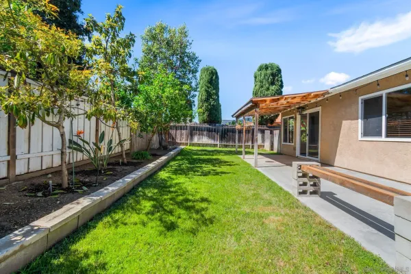 a view of a house with backyard and sitting area