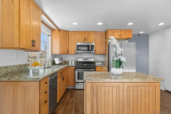 a kitchen with granite countertop a stove a sink a refrigerator and a granite counter tops