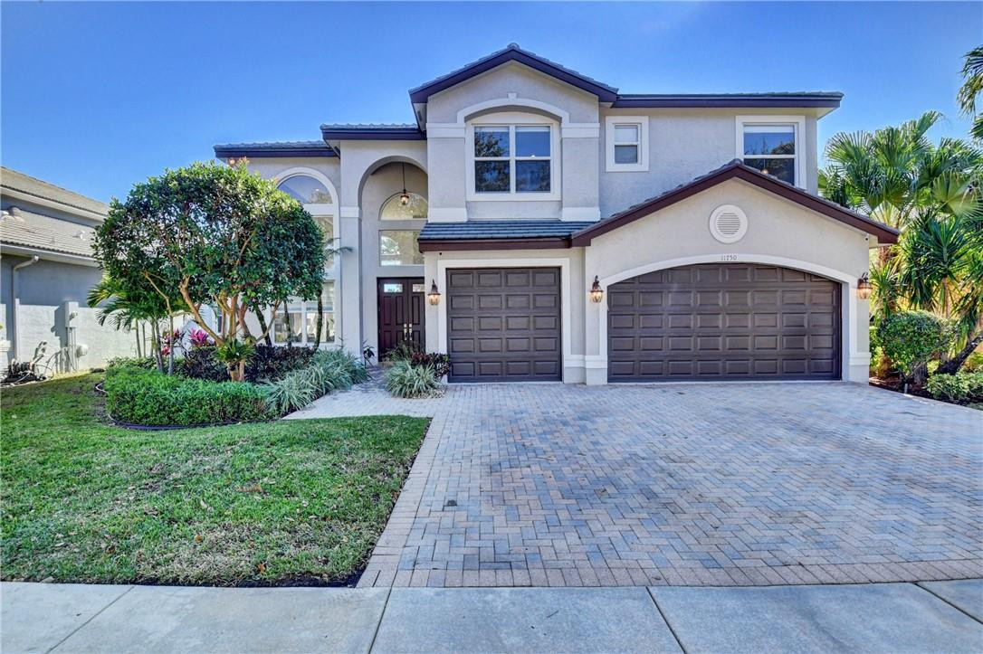 11750 Bayfield Drive Boca Raton, FL 33498 - Photo 13 of 70 a front view of a house with a yard and garage