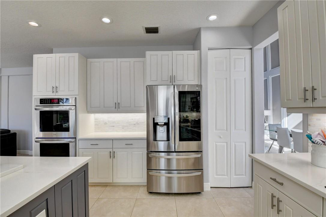 11750 Bayfield Drive Boca Raton, FL 33498 - Photo 25 of 70 a kitchen with kitchen island a counter top space stainless steel appliances and cabinets