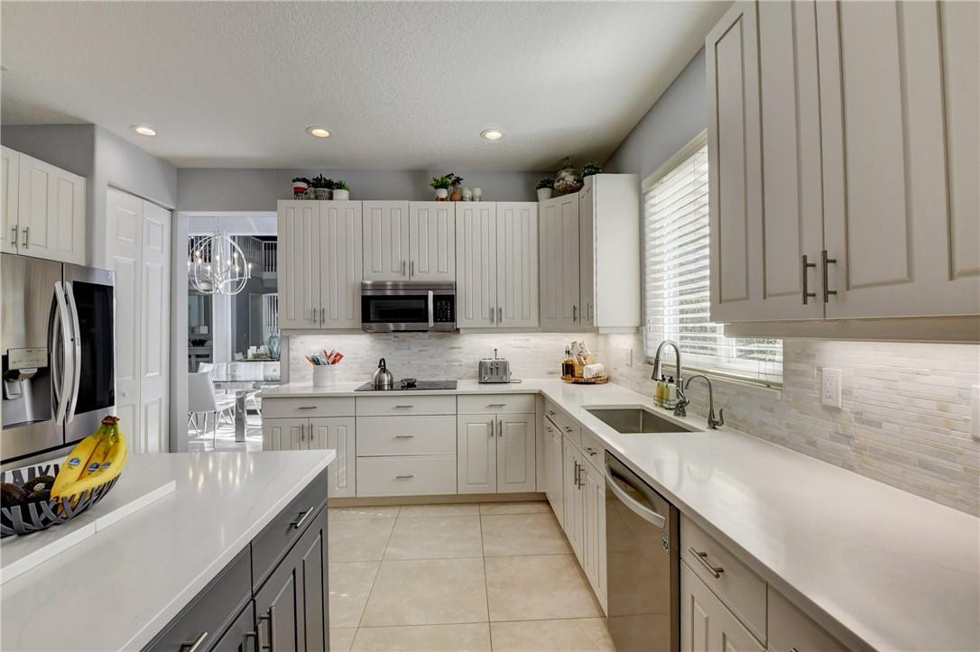 11750 Bayfield Drive Boca Raton, FL 33498 - Photo 29 of 70 a kitchen with a sink stove top oven and refrigerator